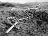 cross pendant on a rock background cross pendant on a rock background
