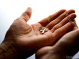 small gold cross in open hands faith small gold cross in open hands faith