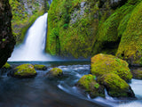 gentle flowing creek with waterfall in background gentle flowing creek with waterfall in background