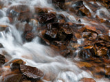 water in creek flows over the orange brown rocks water in creek flows over the orange brown rocks