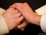 younger woman holds older woman's hands in prayer younger woman holds older woman's hands in prayer