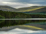green rolling hills in the background of the peaceful lake green rolling hills in the background of the peaceful lake