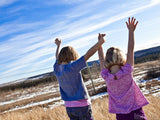 two young girls lifting joined hands high two young girls lifting joined hands high