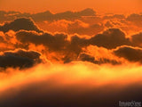 peeking over the clouds in orange peeking over the clouds in orange