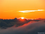 the sun peeking over clouds on an orange background the sun peeking over clouds on an orange background