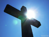 looking up at the sunlight coming through a cross