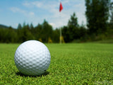 closeup of golf ball and distant pin closeup of golf ball and distant pin