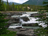 black tiered rock with river flowing over black tiered rock with river flowing over