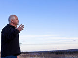 man outside with hand raised man outside with hand raised