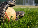 baseball glove on grass with ball in it