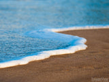 closeup of the foam edge of the wave on sandy beach
