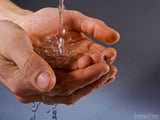water pouring through hands cleansing them