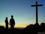 couple standing before the cross