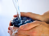 hands holding cup of water being filled