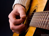closeup of fingers strumming a guitar 
