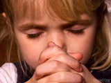 girl with folder hands closed eyes prays
