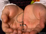 open girls hands holds a cross pendant