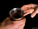 hands passing the communion cup
