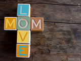 blocks on table spell love and mom
