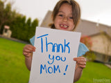 girl holds up card says thank you mom