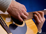 hands playing an acoustic guitar