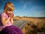 girl on bench praying outside