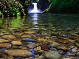 rocks under water and punchbowl falls in the background