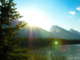 sun light streams of the mountain top onto the lake