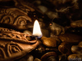 lit oil lamp on stone background