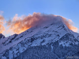 pink cloud on peak of a snow covered mountain