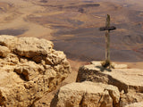 wooden cross on desert rock